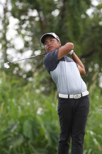 Ira Alido hacks his tee shot on the par-3 No. 4