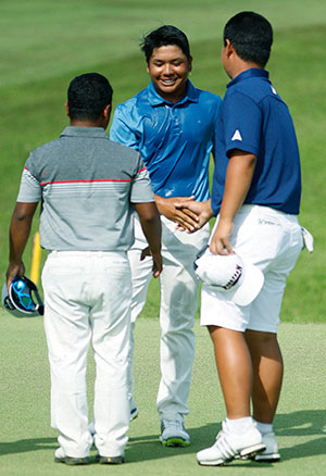A drenched Ira Alido (center) gets a handshake from Kim Joo Hyung (right) and Rupert Zaragosa after clinching the 2-shot victory. Harmie Constantino pumps her fist after securing her 2-stroke win with a closing par.
