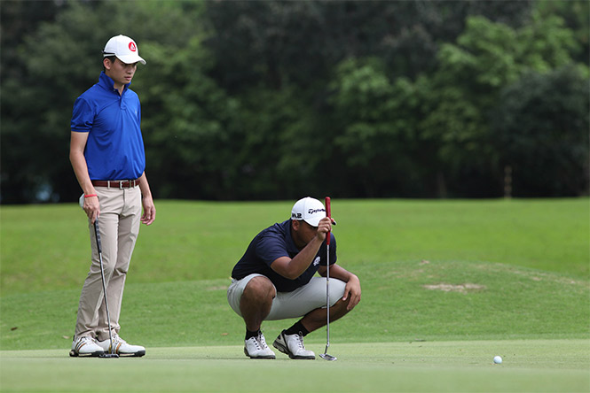 Lester Lagman studies his line of putt on No. 6 as teammate Gab Manotoc looks on during the second day of the National Doubles Amateur Golf Championship.