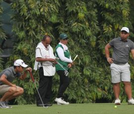 alido study his line in hole 3 with his partner wong waiting